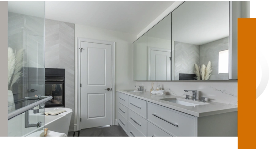 High-end bathroom home renovations by Franklinbuilt featuring a double vanity, marble-style counters, and a chevron tile accent wall with a built-in fireplace.